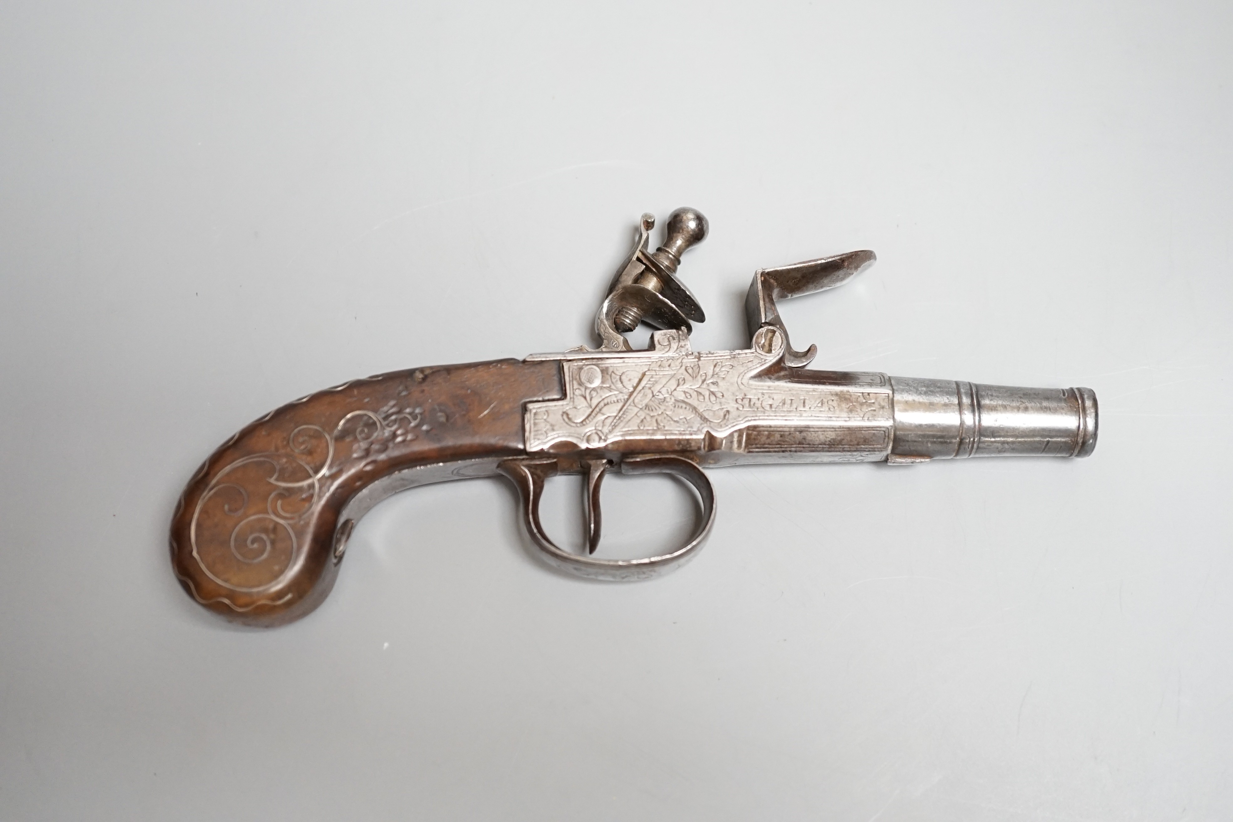 A Flintlock pocket pistol signed Segallas London, c.1770, turn off barrel, signed action engraved with trophies, trigger guard slides to lock mechanism, walnut grip with silver wire inlay, length 16.5cms.